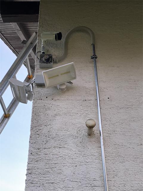 Kamera mit Strahler an der Fassade